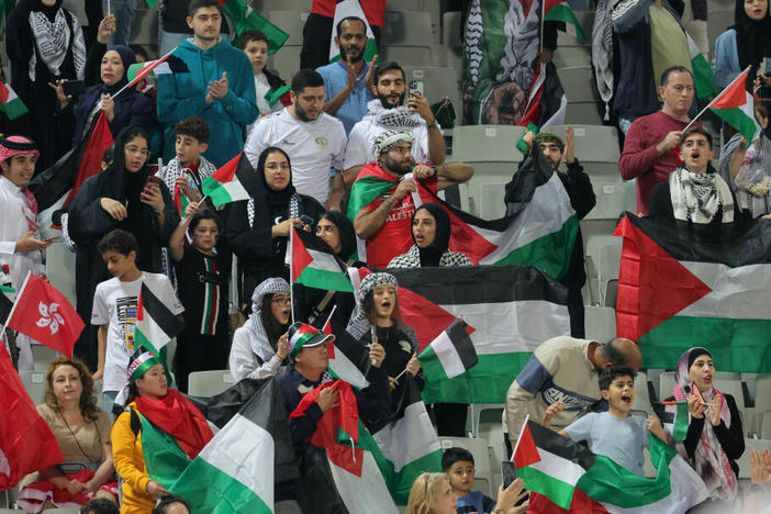 Soccer fans wave Palestinian flags at the AFC Asian Cup Group C soccer match between Hong Kong and the Palestinian soccer team.