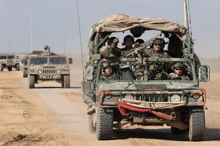 Israeli army troops drive through a dirt road along the border with Gaza in southern Israel on January 25.