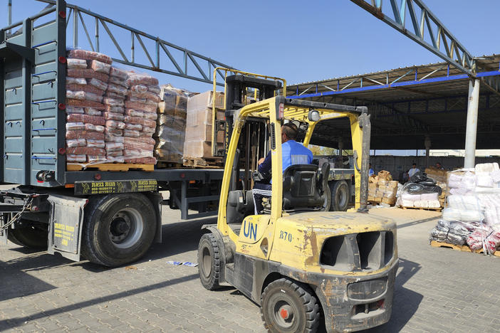 United Nations and Red Crescent workers prepare aid for distribution to Palestinians at a UNRWA warehouse in the Gaza Strip. The U.S. says 12 employees of UNRWA, which provides aid to Palestinians, were involved in Hamas' Oct. 7 attack on Israel.
