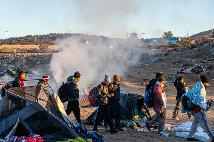 Migrants walk towards a Border Patrol agent in the town of Jacumba. Those crossing the border are often being instructed by cartels to turn themselves over to agents, in order to receive asylum.