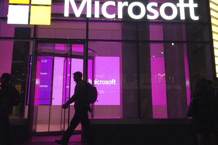 People walk past a Microsoft office in New York in 2016. Big Tech companies, like Google and Microsoft, and dozens of smaller startups have collectively shed more than 20,000 workers so far this year.