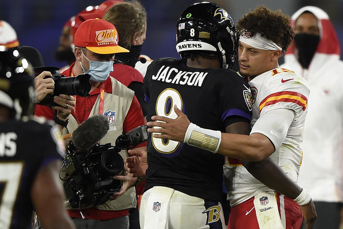 Baltimore Ravens quarterback Lamar Jackson, center, and Kansas City Chiefs quarterback Patrick Mahomes, right, embrace after an NFL football game in 2020, in Baltimore. Jackson and Mahomes will face each other in the AFC championship game in Baltimore on Sunday.