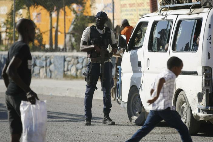 A police officer inspects a public transportation vehicle at a checkpoint in Port-au-Prince, Haiti, Friday, Jan. 26, 2024.