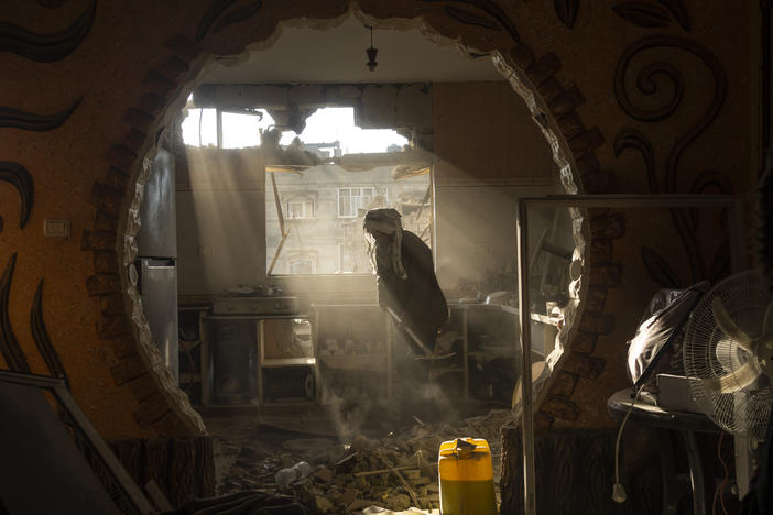 Palestinians look at their neighbor's damaged home following an Israeli strike in Rafah, a city in southern Gaza, on Jan. 27.