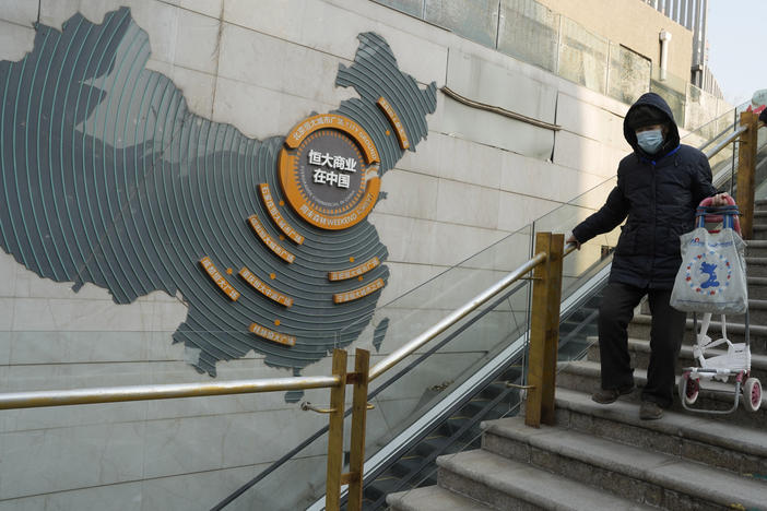 Residents walk through a partially shuttered Evergrande commercial complex in Beijing, Monday, Jan. 29, 2024.