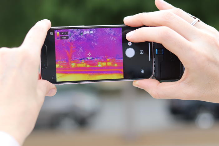 A thermal imaging device attached to an iPhone shows a range of temperatures with reds and oranges representing hot conditions. Some cities are mapping heat to better understand how to prepare for extreme temperatures.