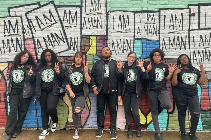 Florentino Escobar (second from right) and the six other Starbucks employees known together as the Memphis 7 stand in front of a Memphis, Tenn., mural that honors the 1968 Memphis sanitation workers strike.