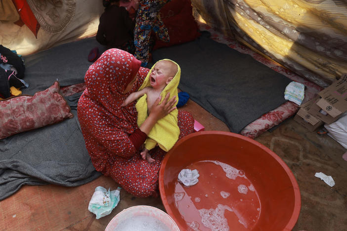 A woman dries a baby in a towel after giving the infant a bath inside a tent at a camp for displaced Palestinians in Rafah, in southern Gaza, on Jan. 18.