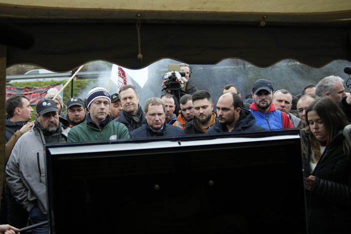 Farmers watch French Prime Minister Gabriel Attal announcing new measures for farmers on a blocked highway on Thursday in Chilly-Mazarin, south of Paris.