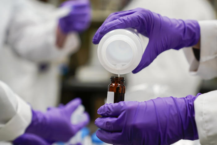 Eva Stebel, water researcher, pours a water sample into a smaller glass container for experimentation as part of drinking water and PFAS research at the U.S. Environmental Protection Agency Center For Environmental Solutions and Emergency Response, Feb. 16, 2023, in Cincinnati.
