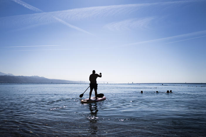 A paddle boarder heads out into the water in Eilat, Israel. Normally, Eilat's beaches and hotels would be busy with tourists.