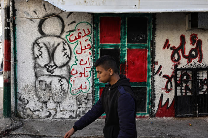 A man walks near a mural of Handala in the village of al-Fara, in the occupied West Bank, following an Israeli raid on Dec. 8.