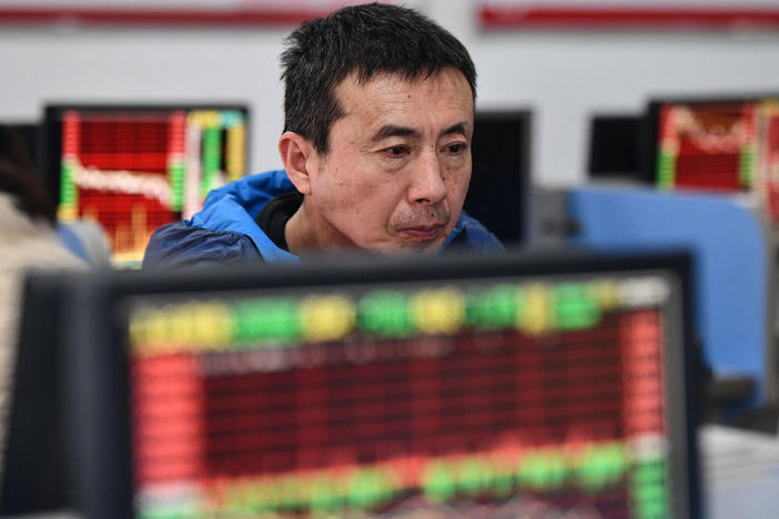 An investor looks at screens showing stock market movements at a securities company in Fuyang in China's eastern Anhui province on Jan. 17.