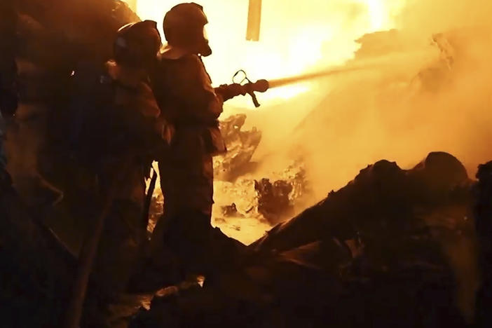 In this image made from video, firefighters work on a fire in Nairobi, Kenya, Friday, Feb. 2, 2024.