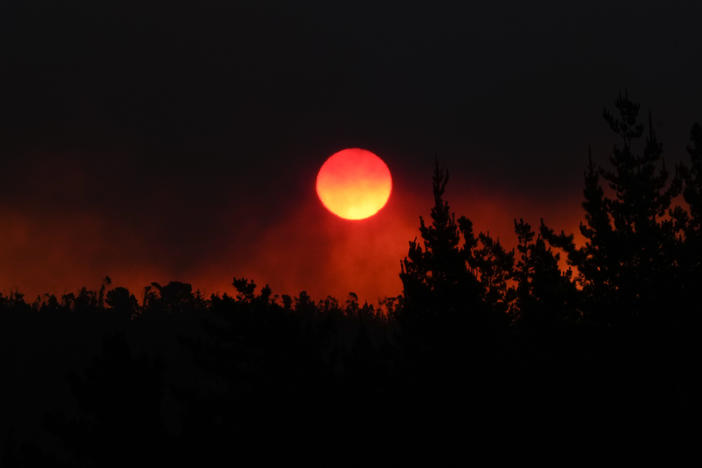 The sun sets as smoke fills the sky caused by the forest fire encroaching on Vina del Mar, Chile, on Saturday. Officials say intense forest fires burning around a densely populated area of central Chile have left dozens of people dead and destroyed hundreds of homes.