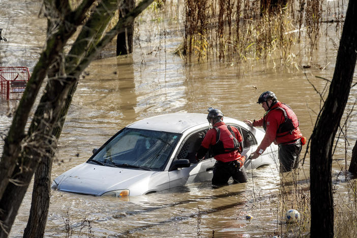 San Jose: Search and rescue workers check a car trapped in flooding after heavy rain caused the Guadalupe River to overflow its banks, Sunday.