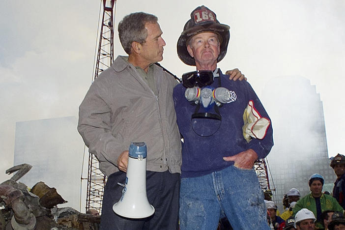 Then-President George W. Bush is shown with New York City firefighter Bob Beckwith on a burnt fire truck in front of the World Trade Center during a tour of the devastation, Sept. 13, 2001.
