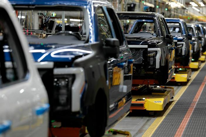 Electric F-150 Lightning pickup trucks travel down the production line at Ford's Rouge Electric Vehicle Center in Dearborn, Michigan on September 8, 2022. Ford has cut two shifts at the plant as it reduces production of the Lightning. But this week Ford CEO Jim Farley told investors "the journey on EVs is inevitable, in our eyes."