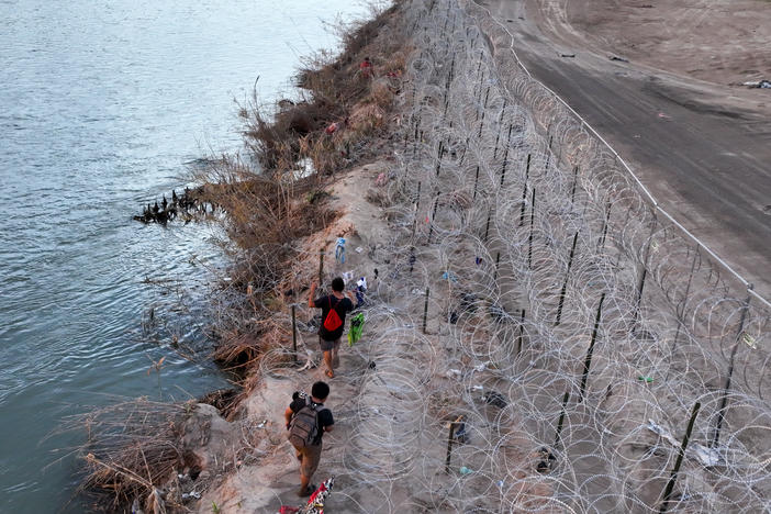 An aerial view of migrants walk next to razor wire as they try to cross Texas border in El Paso, Texas this week to seek humanitarian asylum.  Meanwhile a bill aimed at overhauling immigration is on the verge of collapse in Washington.