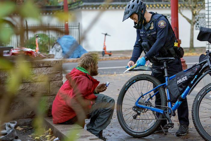 Officer Yoo gives a citation to a man he stopped for using fentanyl in public. Yoo said handing out citations doesn't appear to move people from using drugs on the streets into treatment programs.