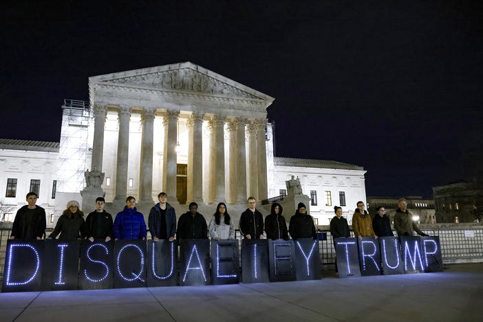 MoveOn members hold signs that read "Disqualify Trump" during a rally outside of the U.S. Supreme Court of the United States earlier this month.  On Thursday, the Court hears arguments in an appeal of a Colorado court ruling that could keep Trump off that state's primary primary ballot.