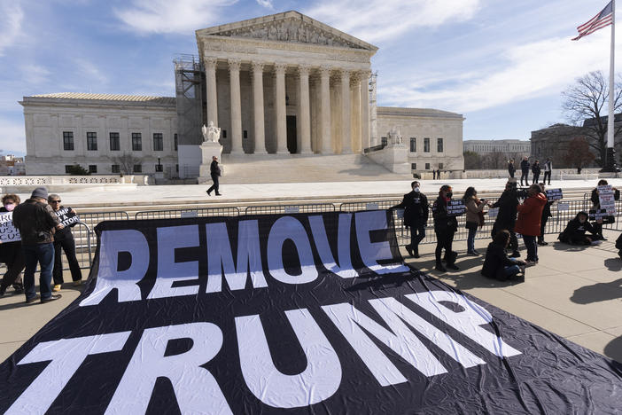A banner is displayed in front of the U.S. Supreme Court on Thursday as justices prepared to hear arguments in a case about whether former President Donald Trump can be disqualified from state ballots. The case has profound implications for the 2024 presidential election.