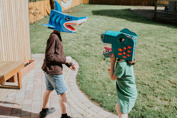 A brother and sister enjoy an imaginative game in a domestic garden on a sunny day. Siblings can have a powerful effect on one another.