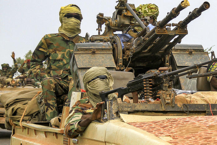 Fighters ride in a vehicle moving in a military convoy accompanying the governor of Sudan's Darfur State on Aug. 30, 2023.