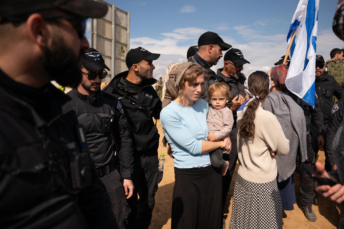 Israeli border police watch over protesters attempting to block the road at the Kerem Shalom border crossing, where Israel inspects trucks and allows them to cross into the Gaza Strip.