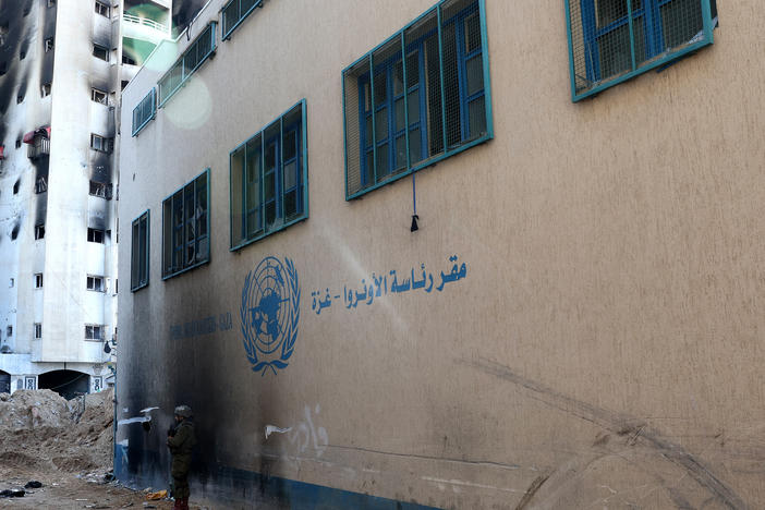 An Israeli soldier standing in front of a United Nations Relief and Works Agency for Palestine Refugees (UNRWA) building in Gaza City. This photo was taken during a controlled tour by the Israeli army on Feb. 8 and subsequently edited under the supervision of the Israeli military.