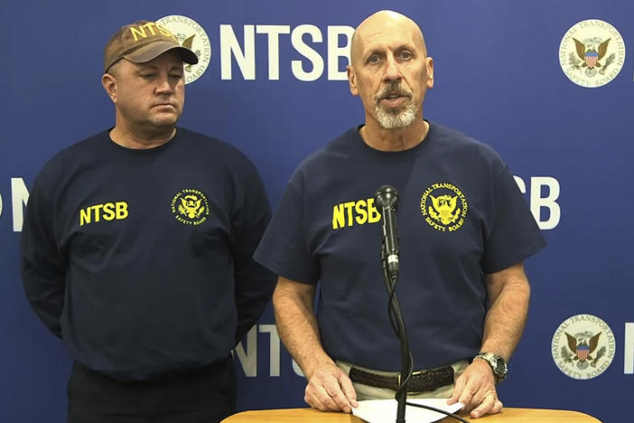 In this image taken from a National Transportation Safety Board video, Michael Graham of the NTSB, which is investigating a deadly helicopter crash that happened in Southern California's Mojave Desert speaks to the media in Barstow, Calif., Saturday, Feb. 10, 2024. The CEO of one of Nigeria's largest banks along with his wife and son were among those killed in Friday's crash.