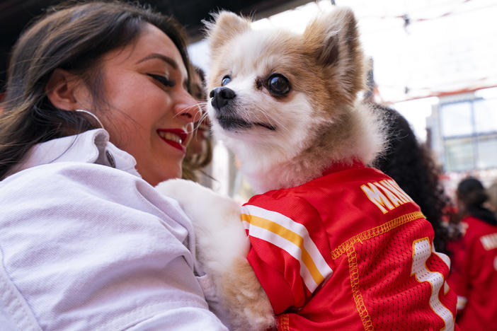 A dog dressed in a Patrick Mahomes jersey and its owner enter the Power and Light Entertainment District as fans prepare to watch the Kansas City Chiefs play the Philadelphia Eagles in the Super Bowl on Feb. 12, 2023 in Kansas City, Mo.