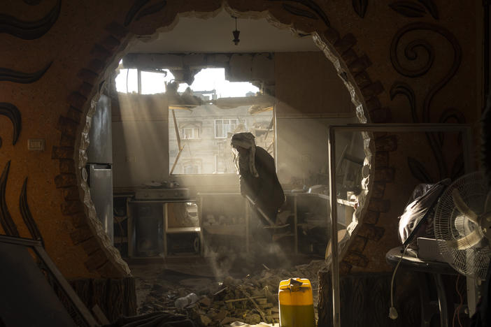 Palestinians look at their neighbor's damaged house following an Israeli strike in Rafah, southern Gaza Strip, Saturday, Jan. 27, 2024.