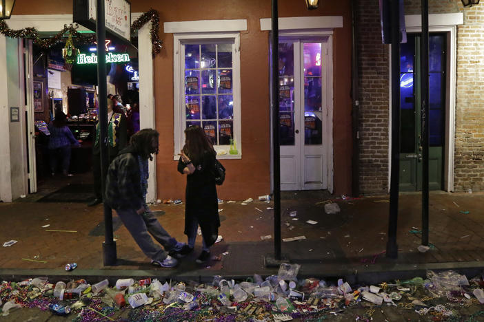 Trash lines the gutter on Bourbon Street, in the early hours of the morning after Mardi Gras, in New Orleans, Feb. 18, 2015. It's a beloved century-old Carnival season tradition in New Orleans — masked riders on lavish floats fling strings of colorful beads or other trinkets to parade watchers clamoring with outstretched arms.