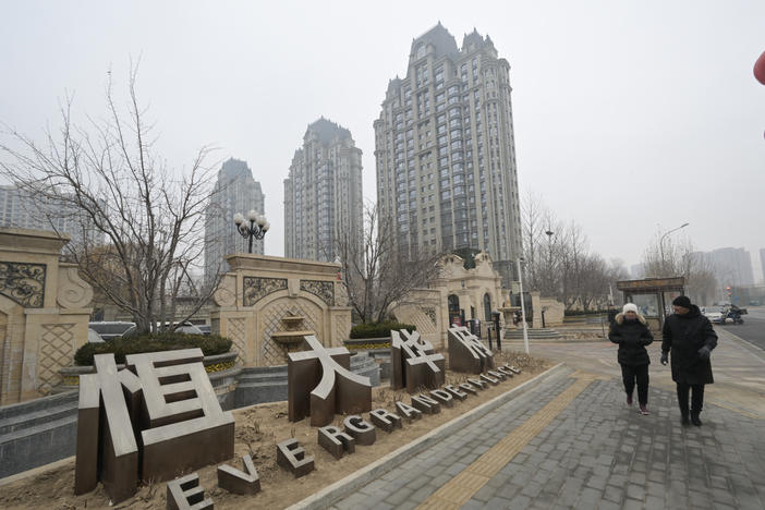 People walk past an Evergrande Group residential complex a day after a Hong Kong court ordered the liquidation of China's property giant Evergrande