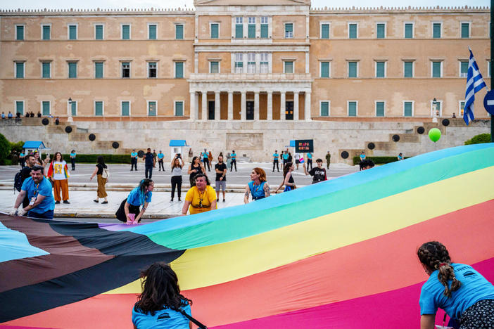Participants hold a giant rainbow flag in front of the Greek parliament during the Athens Pride parade in Athens on June 10, 2023.
