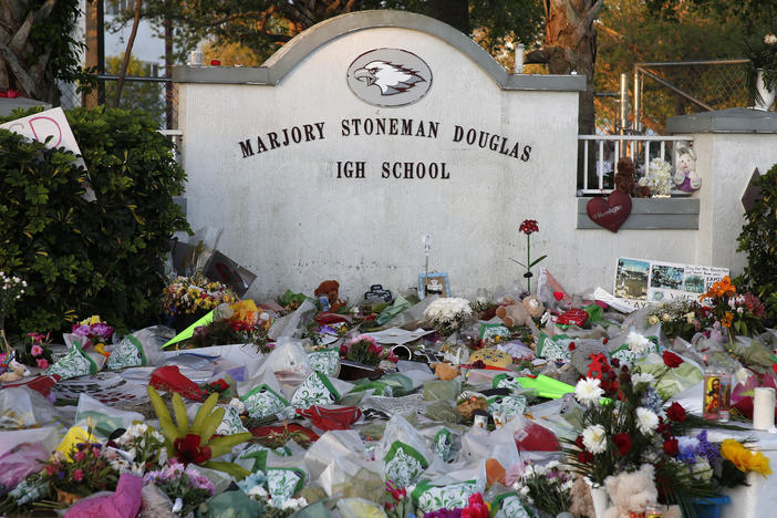 Flowers, candles and mementos sit outside one of the makeshift memorials at Marjory Stoneman Douglas High School in Parkland, Florida just days after the deadly shooting in 2018.