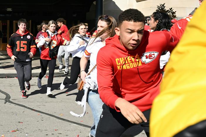 People flee after shots were fired near the Kansas City Chiefs' 2024 Super Bowl victory parade on Wednesday in Kansas City, Mo.