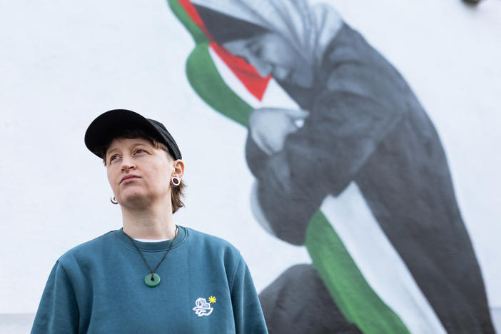 Emmalene Blake poses for a portrait in front of her mural showing Samia al-Atrash holding her niece Masa Khader, who was killed by an Israeli airstrike in Gaza in October.