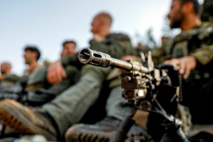 An Israeli army soldier sits by a machine gun deployed on a tripod at a position in the upper Galilee region of northern Israel near the border with Lebanon on October 28, 2023 amid increasing cross-border tensions between Hezbollah and Israel as fighting continues in the south with Hamas militants in the Gaza Strip.