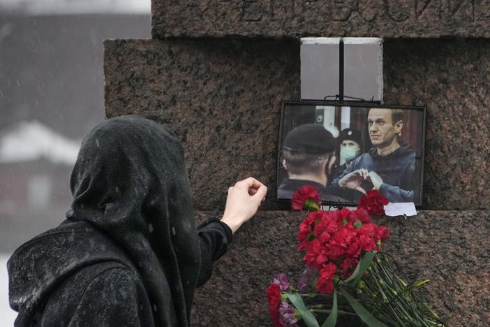 A woman touches a photo of Alexei Navalny after laying flowers at the Memorial to Victims of Political Repression in St. Petersburg, Russia, on Saturday.