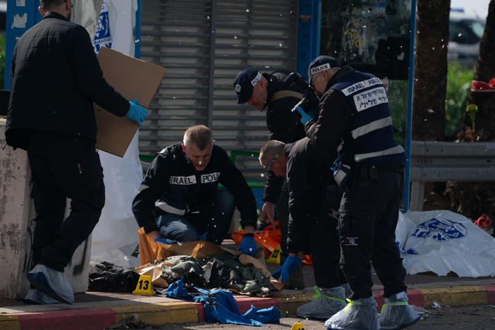 Israeli police investigate the site of a shooting attack at the Masmiya-Re'em junction in southern Israel on Friday, Feb. 16.