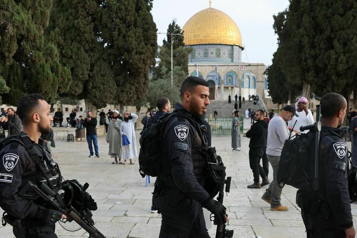 Jewish visitors walk protected by Israeli security forces at the Al-Aqsa mosque compound, also known as the Temple Mount complex to Jews, in Jerusalem on April 9, 2023, during the Muslim holy fasting month of Ramadan, also coinciding with the Jewish Passover holiday.