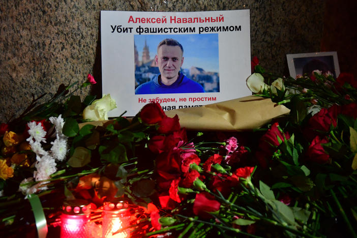 Flowers lay next to a picture of late Russian opposition leader Alexei Navalny at a makeshift memorial organized at the monument to the victims of political repressions in Saint Petersburg.