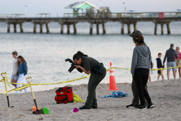 Investigators on the beach in Lauderdale-by-the-Sea, Fla., take photos of the scene of a sand collapse on Tuesday, Feb. 20, 2024.