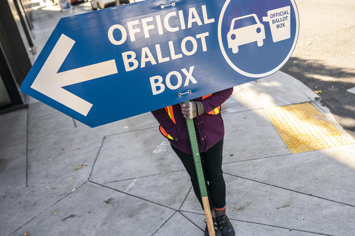 An election worker directs voters to a ballot drop-off location in 2020 in Portland, Ore. Oregon is among the states waiting for the Biden administration to greenlight plans to automatically register eligible voters when they apply to enroll in Medicaid.