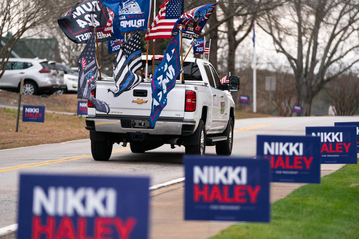 A supporter of former President Donald Trump drives past campaign signs for Republican presidential candidate Nikki Haley in Irmo, South Carolina. The state's Republican presidential primary is on Feb. 24.