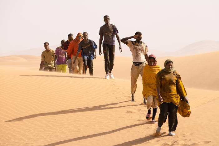 Seydou (Seydou Sarr, in gray) crosses the desert in <em>Io Capitano.</em>
