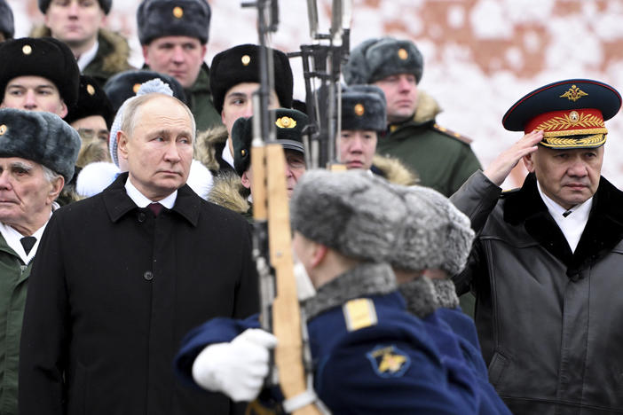 Russian President Vladimir Putin and Defense Minister Sergei Shoigu (right) take part in a wreath-laying ceremony at the Tomb of the Unknown Soldier in Alexander Garden on Defender of the Fatherland Day, in Moscow, Friday.