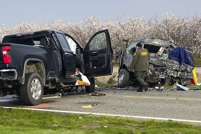 The site of a head-on crash involving a van and a pickup truck where eight people were killed is checked in Madera County, Calif., on Friday.